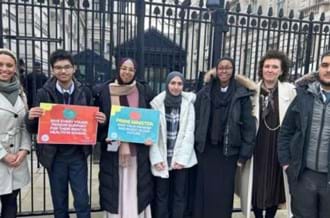 A group of 5 politics students from Ark King Soloman Academy, standing outside Downing Street with their teacher and CEO of Place2Be, Catherin Roche
