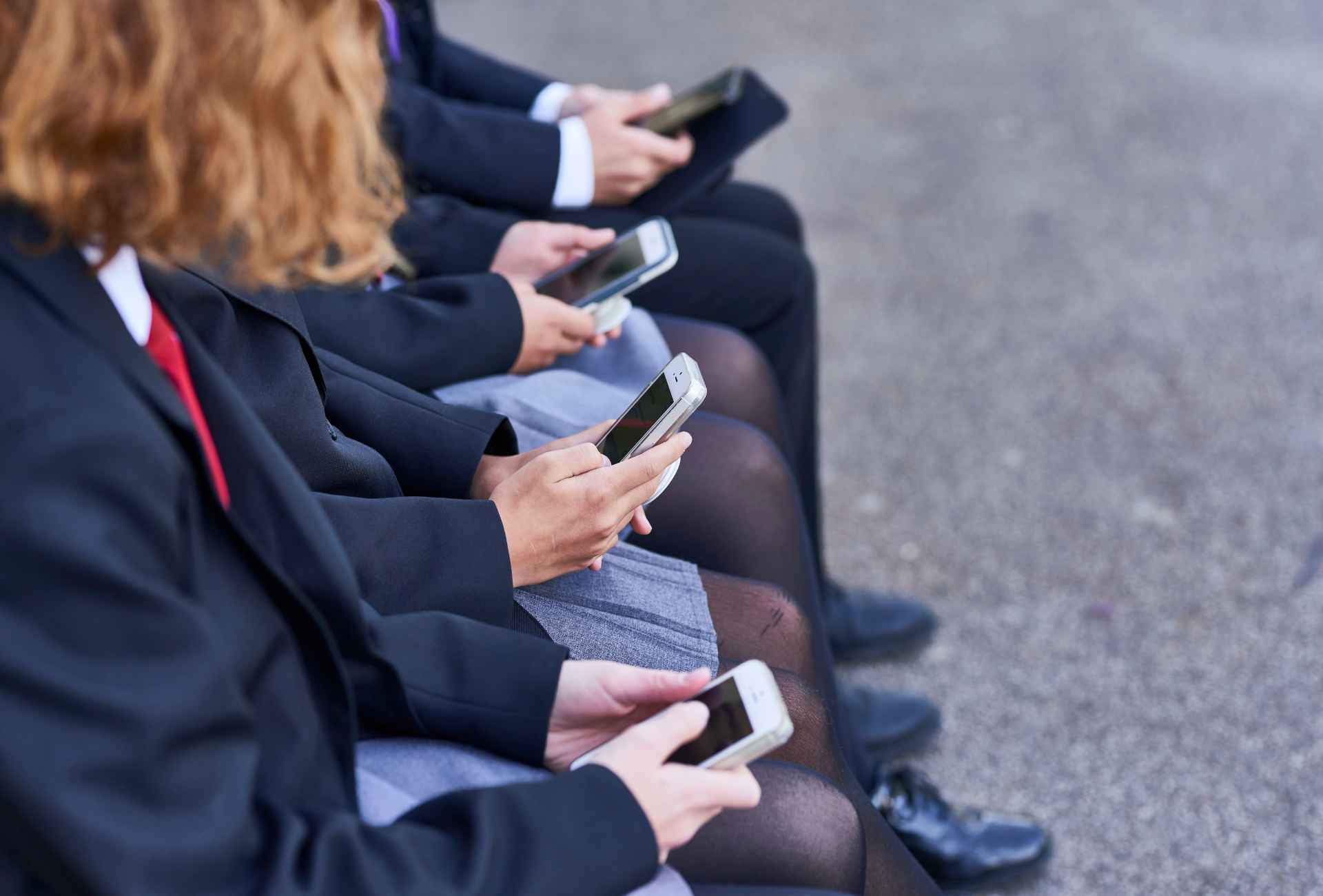 four young people on their phones