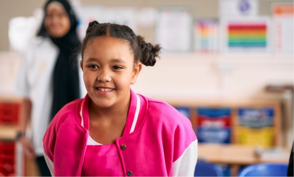 young girl wearing pink smiling